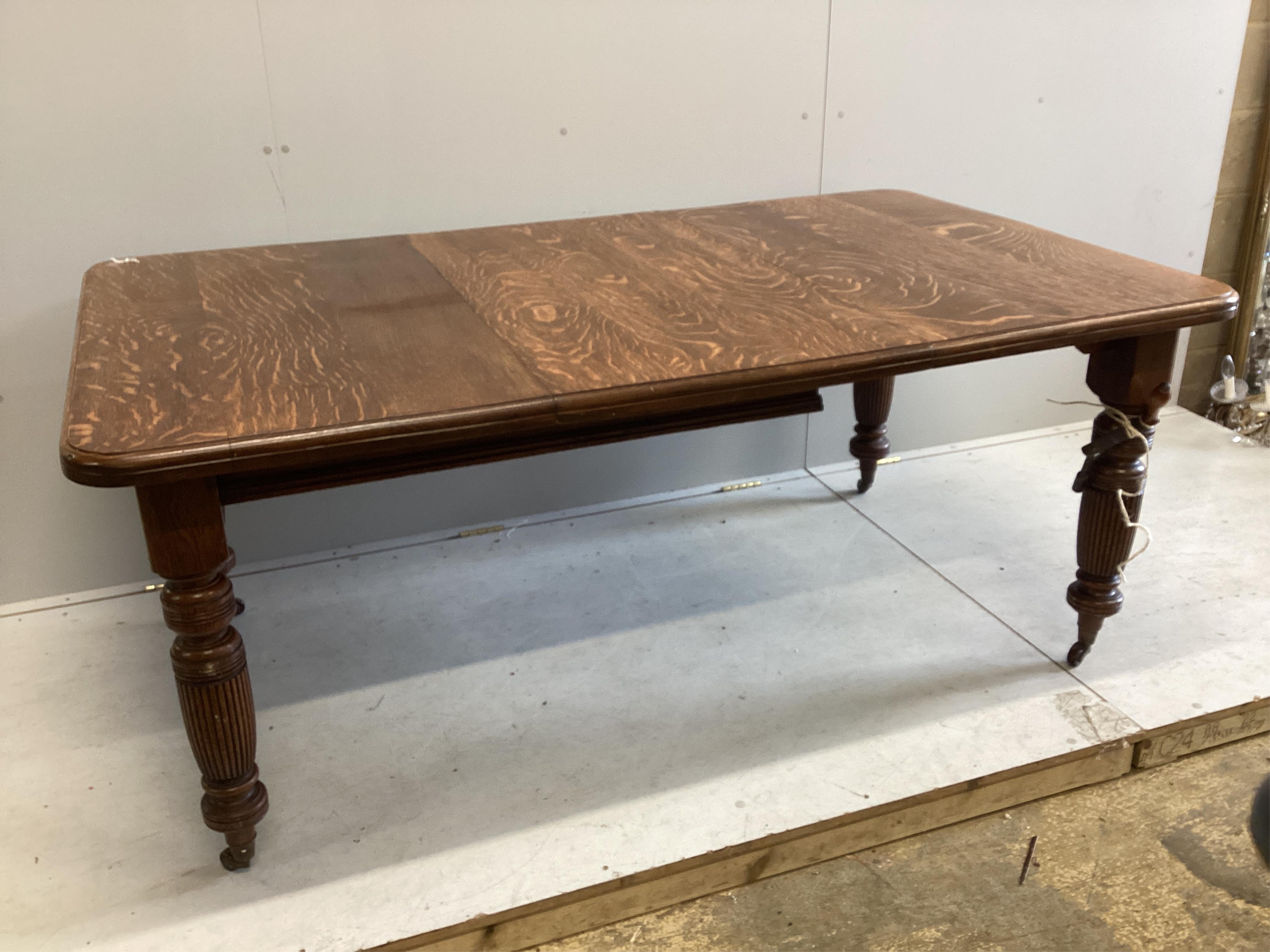 A late Victorian oak extending dining table, extended 174cm, one spare leaf, depth 104cm, height 73cm. Condition - fair